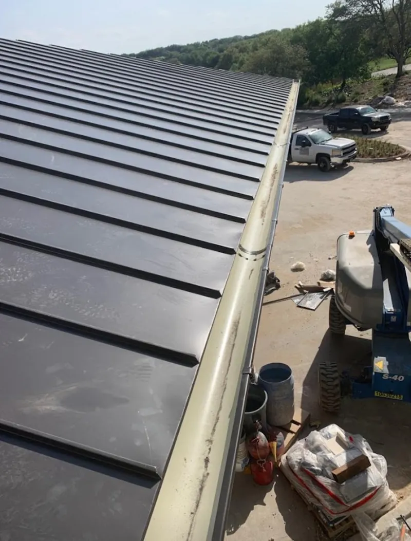 Standing seam panel and gutter detail on a metal roofing jobsite in Annandale